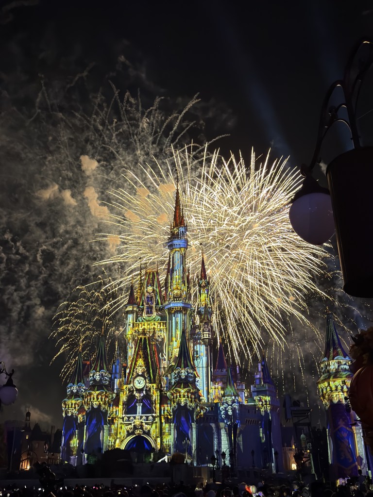 Fogos de artifício dourados sobre o castelo iluminado do Magic Kingdom durante a festa de Halloween