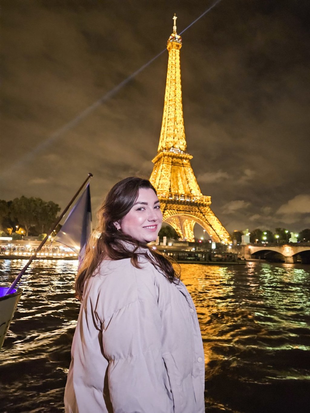 Gabriela Bordin no rio Sena, com a Torre Eiffel iluminada ao fundo, em Paris