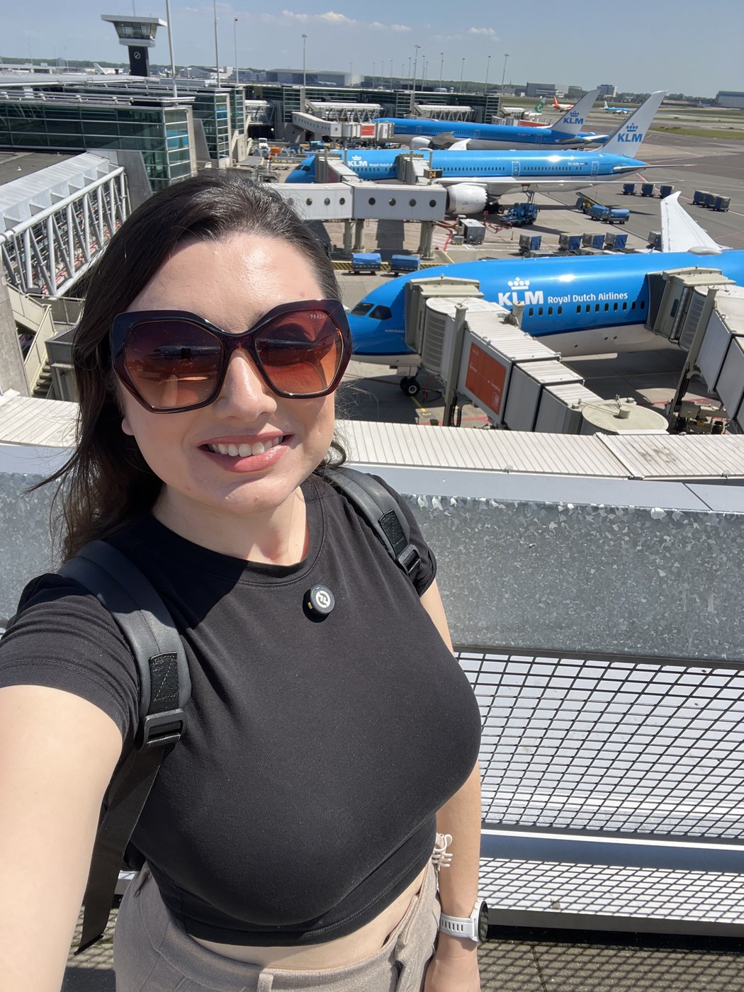 Gabriela Bordin no terraço do aeroporto de Schiphol, com aviões da KLM ao fundo